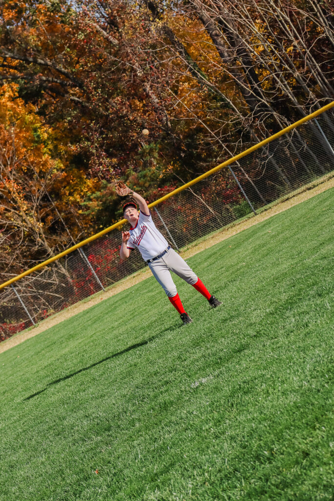 Pioneer Baseball League youth athlete kid player warms up during championship game