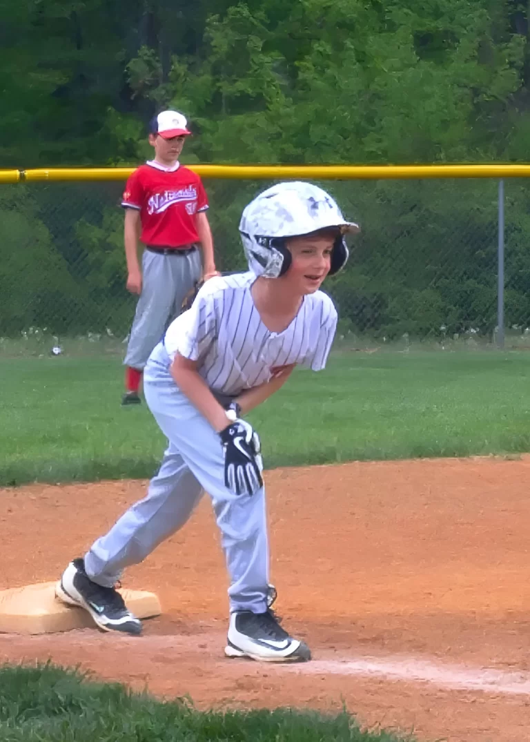 Image of Wesley Lipicky playing baseball standing on third base smiling